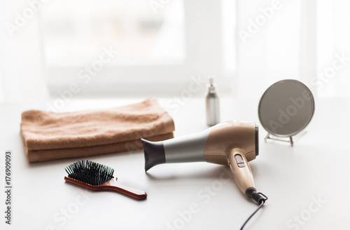 Fotografie hairdryer, hair brushes, mirror and towel