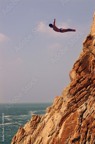 Acapulco coast. Divers diving from the rock. Mexico. photo