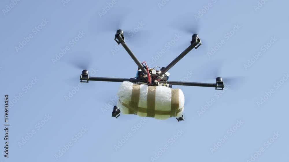 CLOSE UP: Drone delivery of illegal drugs. UAV aircraft flying drug stash across the border. Air drone smuggling illegal drugs. Drug gangs and narco cartels using drone to drop off a cocaine package CLOSE UP: Drone delivery of illegal drugs. UAV aircraft flying drug stash across the border. Air drone smuggling illegal drugs. Drug gangs and narco cartels using drone to drop off a cocaine package