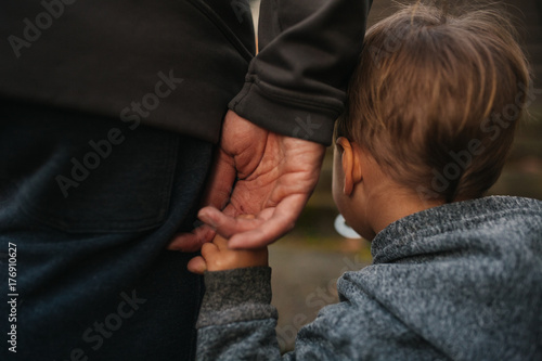 Cute little boy holding dad's hand