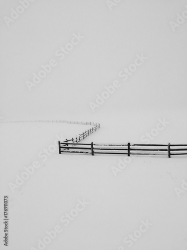 Lonely fense winding in winter snow photo