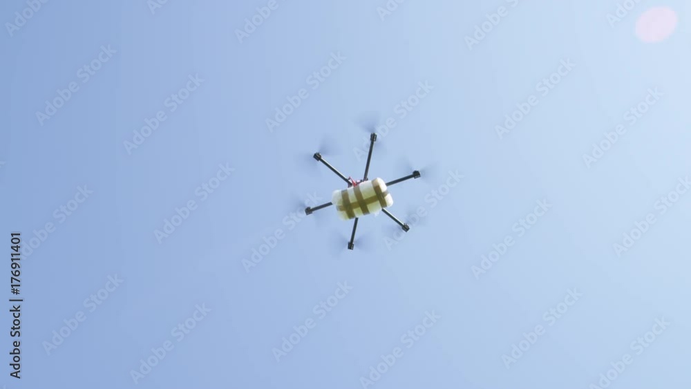 CLOSE UP: Drone delivery of illegal drugs. UAV aircraft flying drug stash across the border. Air drone smuggling illegal drugs. Drug gangs and narco cartels using drone to drop off a cocaine package CLOSE UP: Drone delivery of illegal drugs. UAV aircraft flying drug stash across the border. Air drone smuggling illegal drugs. Drug gangs and narco cartels using drone to drop off a cocaine package