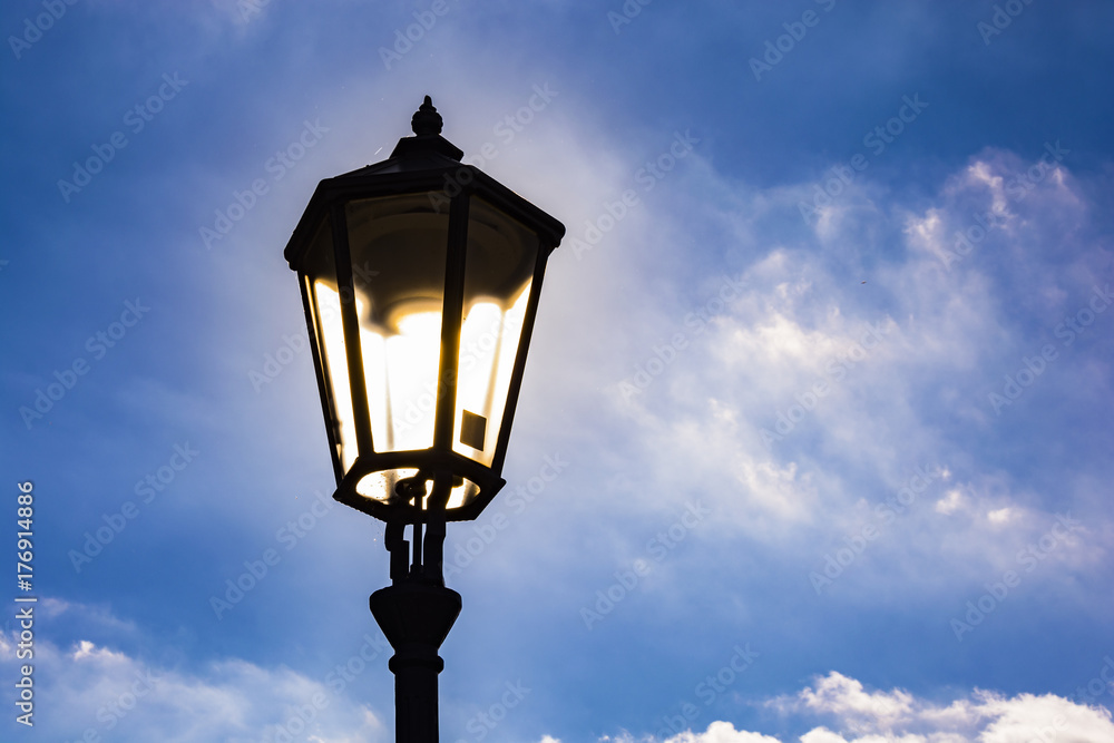 Lighting street lamp under blue sky with fairy tale´s clouds.