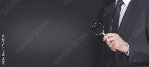 suit businessman holding a magnifying glass photo
