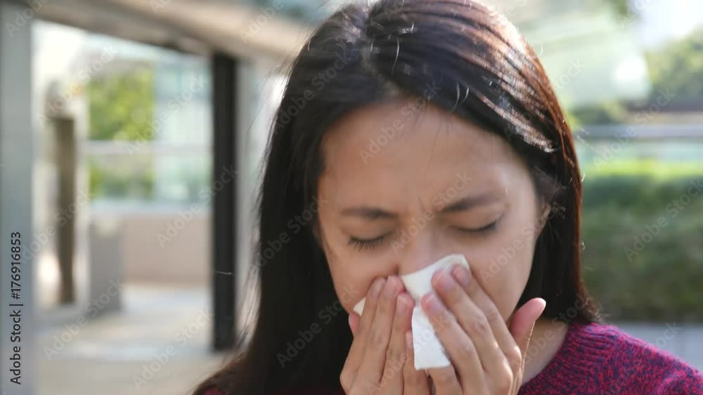 Woman sneezing at outdoor at autumn season Woman sneezing at outdoor at autumn season