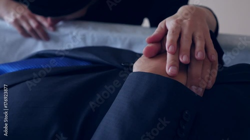 funeral, sadness and mourning concept - sad woman talking and crying next to the coffin. 4k,