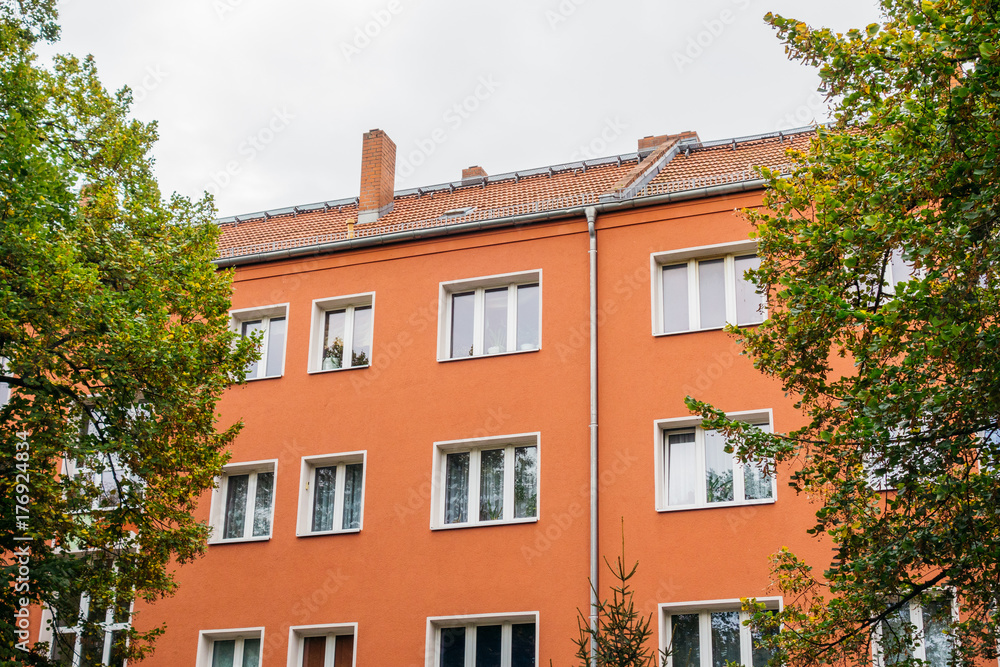 red apartment house between trees red apartment house between trees
