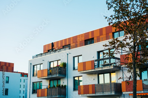 white facaded building with red modern roof