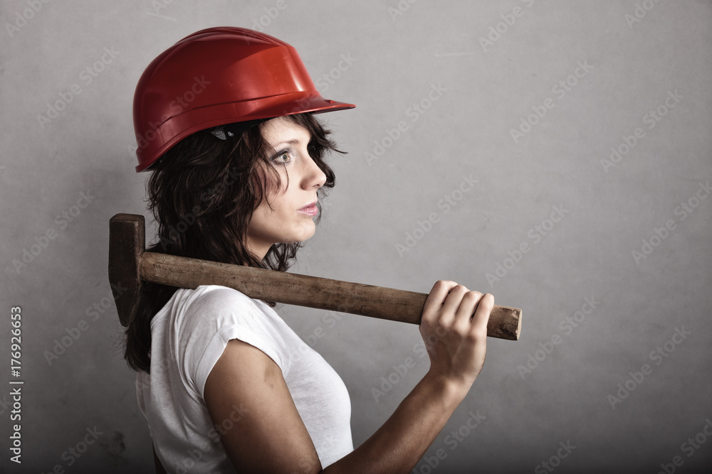 Sexy girl in safety helmet holding hammer tool Sexy girl in safety helmet holding hammer tool