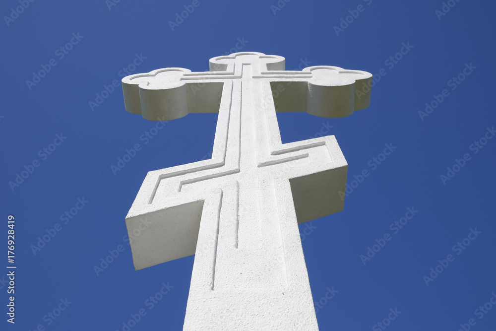 White orthodox christian cross on blue sky background.