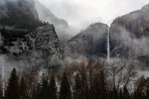 A fog rolls over Upper Yosemite Falls in Yosemite National Park, California photo
