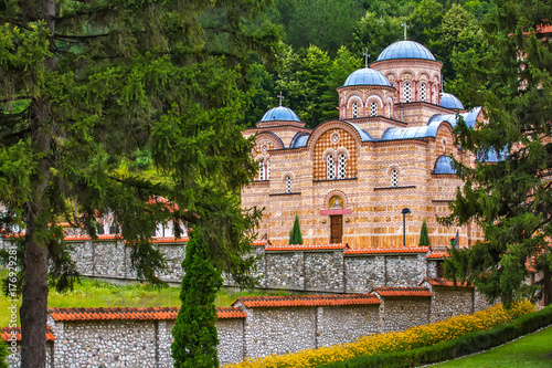 Orthodox church with a beautiful stone fence surrounded by fairy-tale nature, trees and mountain forest. Temple Trocrkva, Valjevo, Serbia. photo