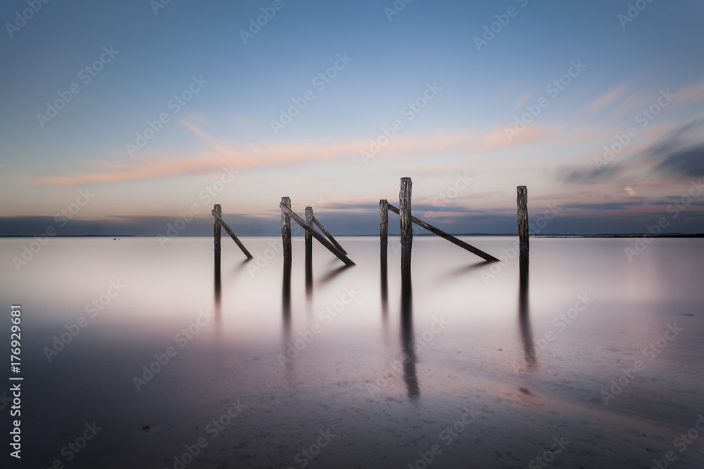 Old jetty poles in a glassy ocean twilight at Flinders, Victoria Old jetty poles in a glassy ocean twilight at Flinders, Victoria