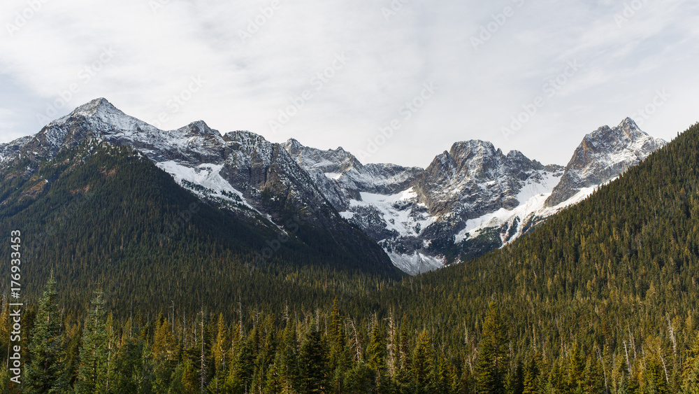 Early winter snow during Autumn season covering mountain peaks in the North Cascades National Park with Fisher Peak on the right.