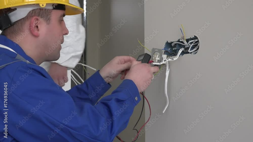 Professional electrician man using special tool to check wall socket voltage