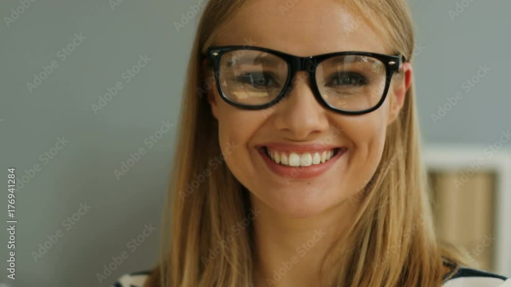 Close up portrait of happy business woman in the glasses looking straight at the camera and smiling on the office background. Close up portrait of happy business woman in the glasses looking straight at the camera and smiling on the office background.