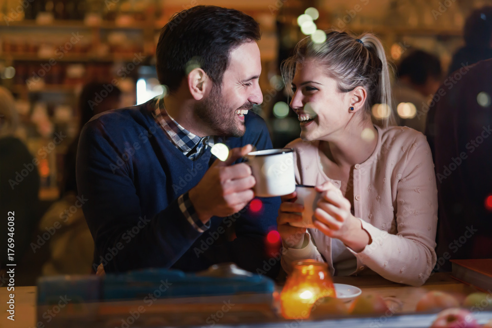 Happy couple talking at bar and having date