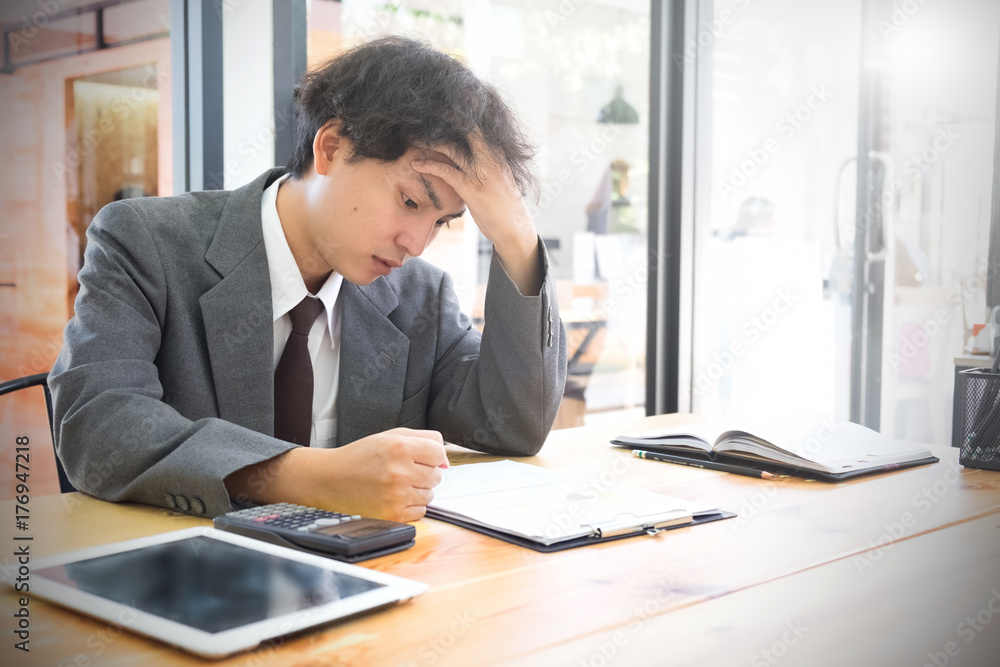 Business issues concept, business man headache in office with finance report on table. Business issues concept, business man headache in office with finance report on table.