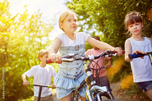 Kinder fahren mit Fahrrad und Roller im Sommer © Robert Kneschke