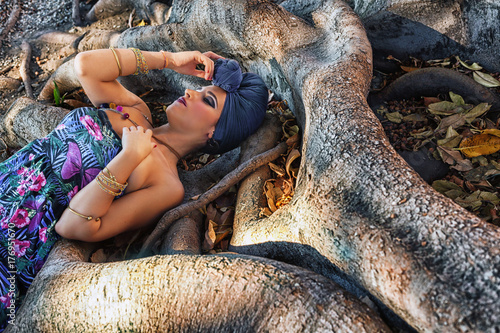 ragazza con turbante posa su albero millenario photo