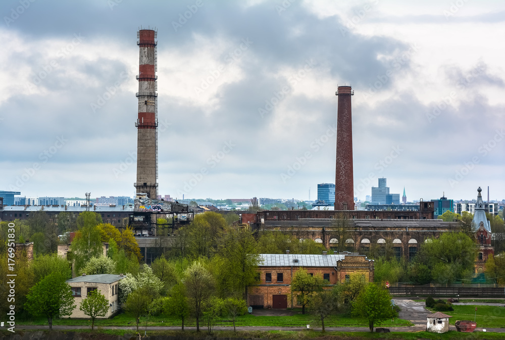 Industrial landscape with two pipes against cloudy sky