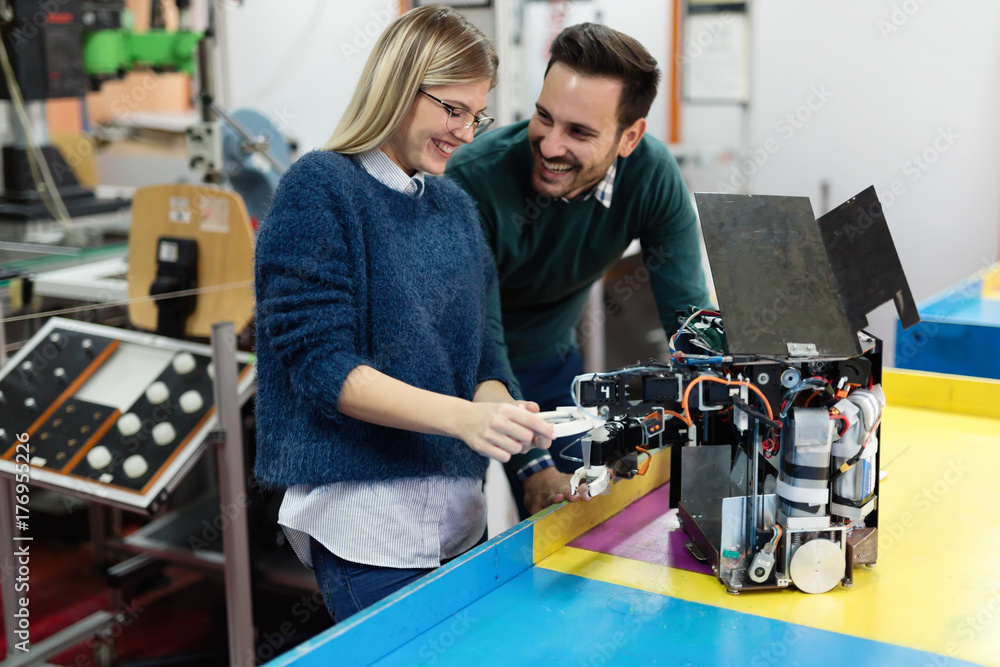 Young students of robotics preparing robot for testing Young students of robotics preparing robot for testing