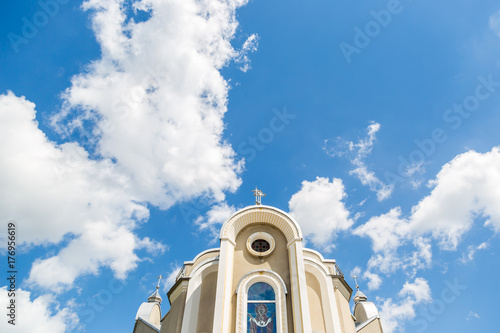 Christian church against the blue sky with clouds background. Background photo