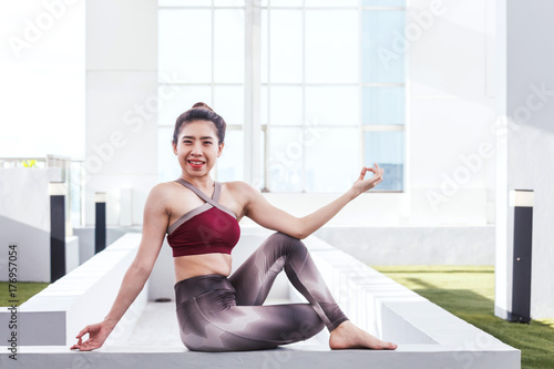 Woman practicing yoga in front of a large window