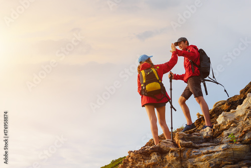 Young asian couple climbing up on the mountain,hiking and team work concept.