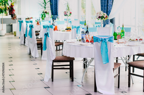 the restaurant is decorated with decorators and florists . The bows on the chairs   flowers on the tables