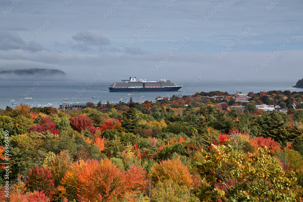 Naklejka premium Cloudy morning in Maine overlooking fall foliage and cruise ship departing.