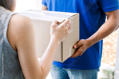 Tablou pe pânză Woman accepting a delivery boxes from delivery man