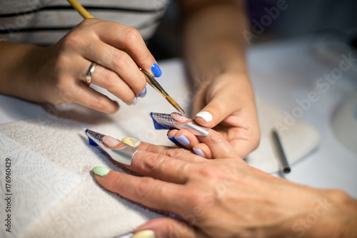 Manicure. Master make nail extension. hands closeup.