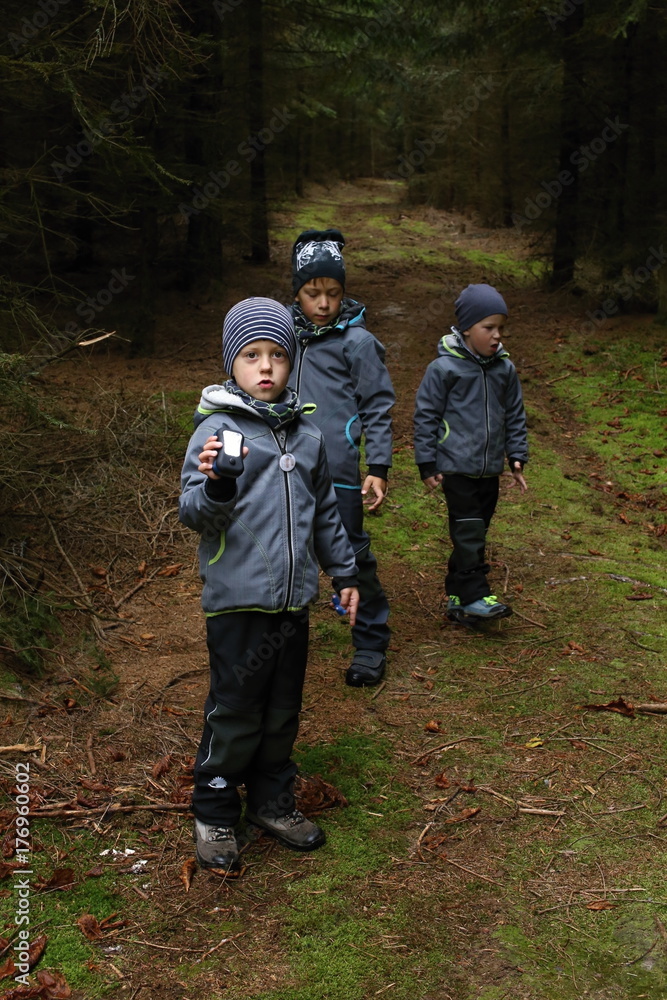 Three boys playing with lanterns in the woods