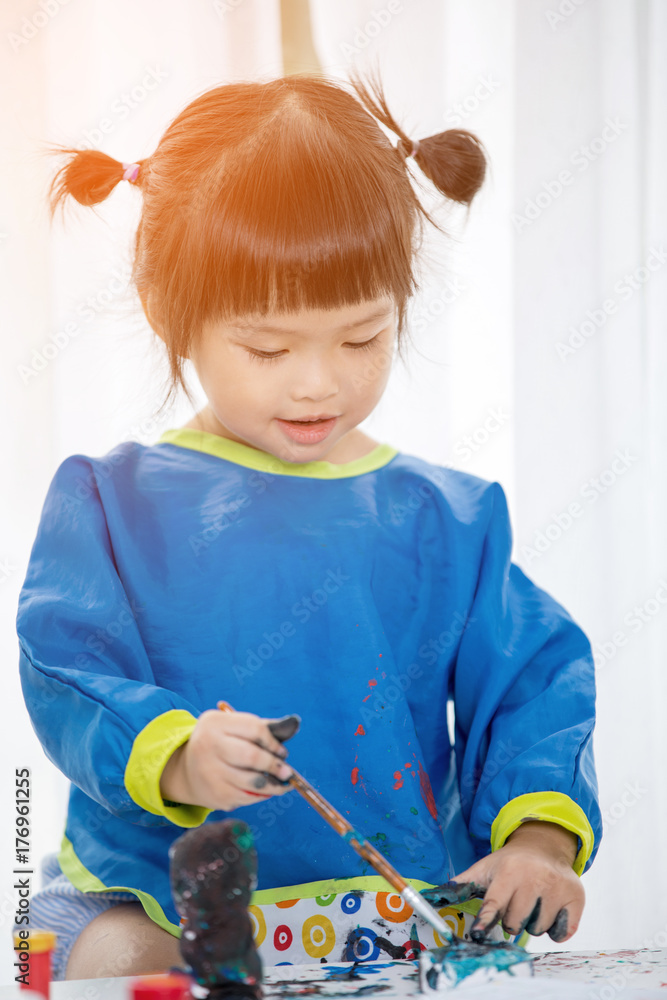 Portrait of a cute little girl messily playing with paints. Portrait of a cute little girl messily playing with paints.