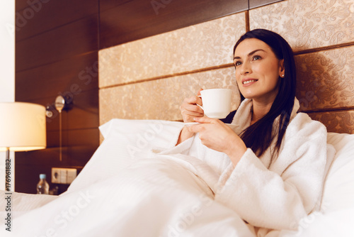Delighted woman relaxing at hotel room