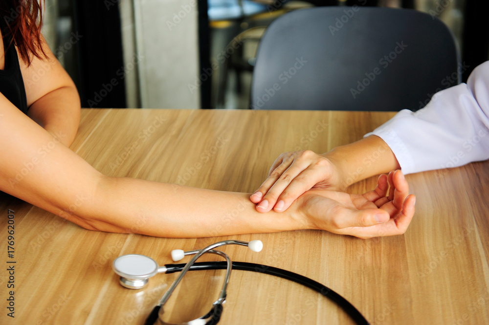 Doctor taking the pulse of the patient's wrist and the stethoscope in the hospital Doctor taking the pulse of the patient's wrist and the stethoscope in the hospital