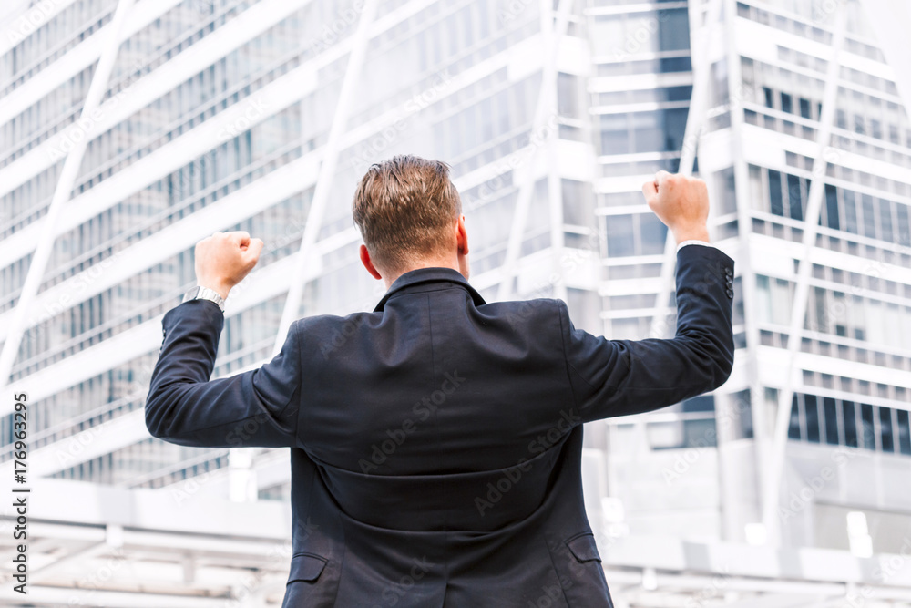Successful businessman celebrating with arms up Successful businessman celebrating with arms up