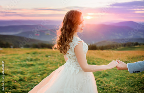 Evening sun shines from behind stunning young bride