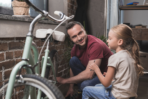 Father repairing daughters bicycle