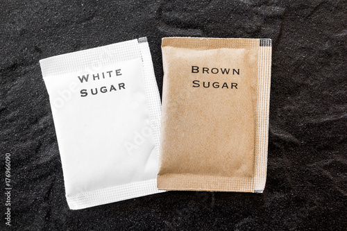 White and brown sugar bag on black background