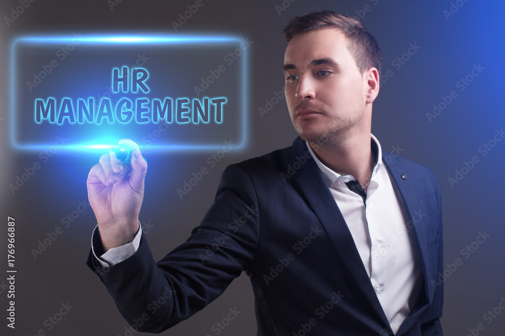 The concept of business, technology, the Internet and the network. Young businessman showing inscription: HR management The concept of business, technology, the Internet and the network. Young businessman showing inscription: HR management