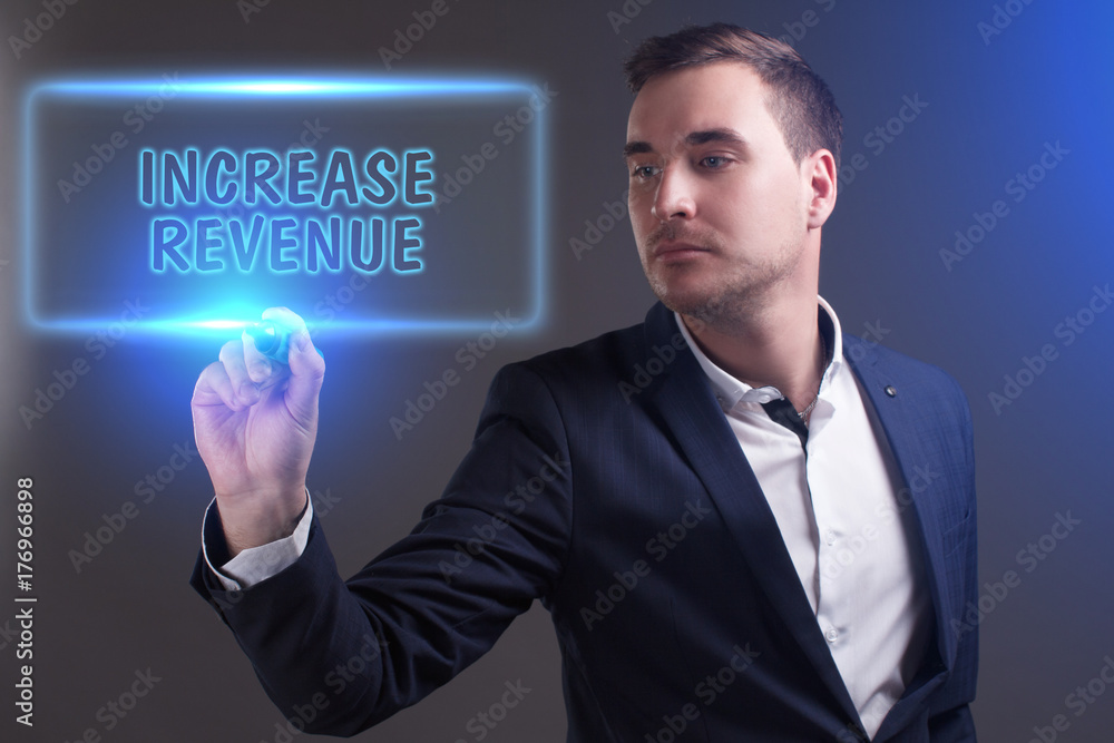 The concept of business, technology, the Internet and the network. Young businessman showing inscription: Increase revenue The concept of business, technology, the Internet and the network. Young businessman showing inscription: Increase revenue