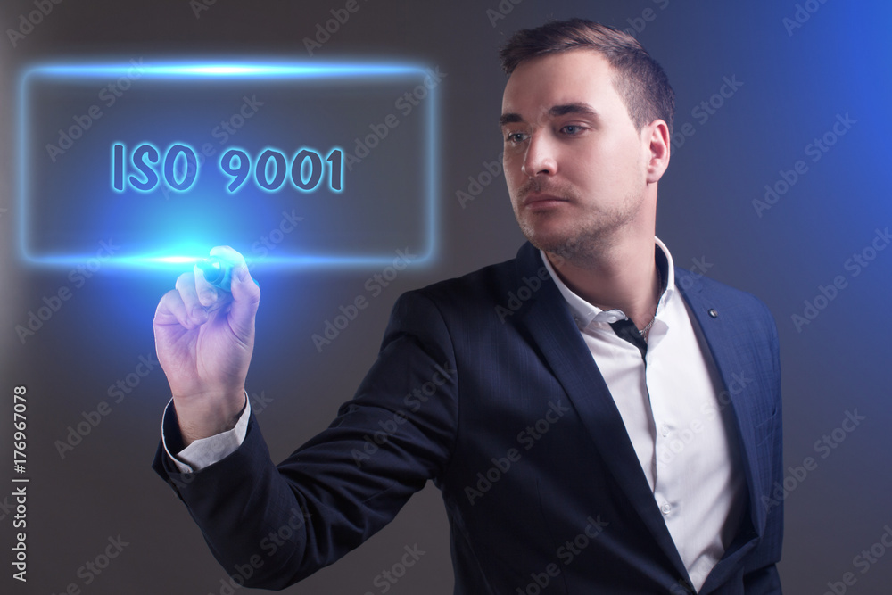 The concept of business, technology, the Internet and the network. Young businessman showing inscription: ISO 9001 The concept of business, technology, the Internet and the network. Young businessman showing inscription: ISO 9001