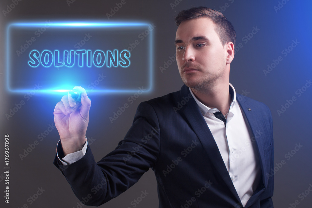 The concept of business, technology, the Internet and the network. Young businessman showing inscription: Solutions The concept of business, technology, the Internet and the network. Young businessman showing inscription: Solutions