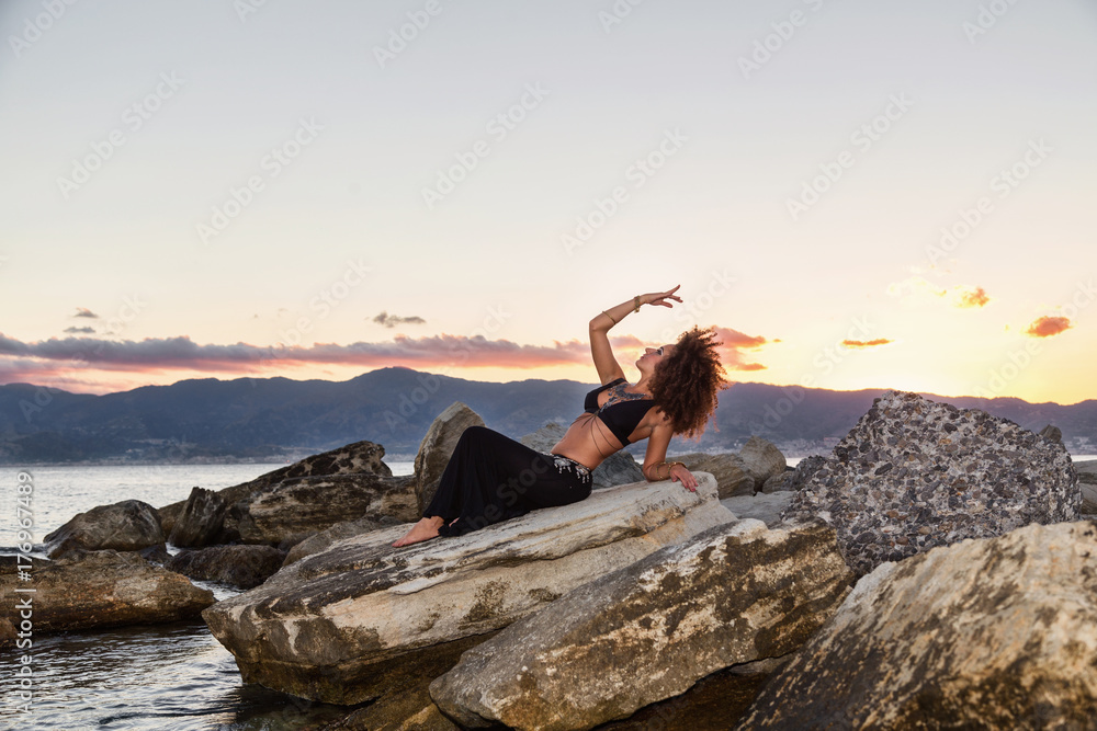 ragazza danza sugli scogli al tramonto in riva al mare ragazza danza sugli scogli al tramonto in riva al mare