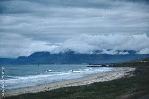 Photography the austere Icelandic landscape with field in the foreground and the mountains a