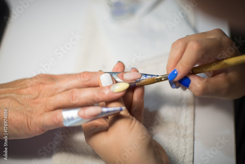 Manicure. Master make nail extension. hands closeup.