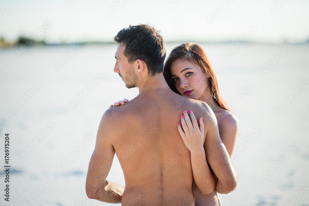 Stunning brunette hugs naked man and holds her hands on his back Stunning brunette hugs naked man and holds her hands on his back