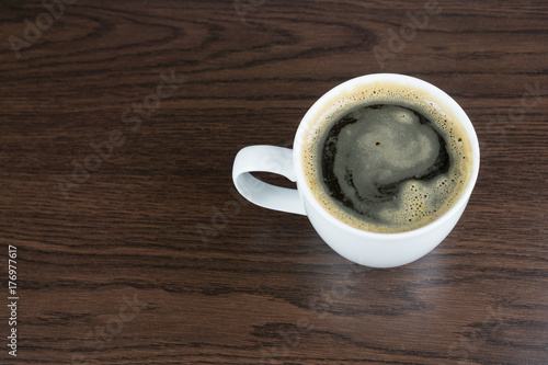 A cup of coffee on a brown wood table